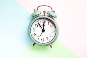 Retro style alarm clock over the pastel background