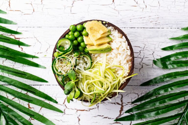 plant based protein bowl with avocado, green peas, zucchini on a white table